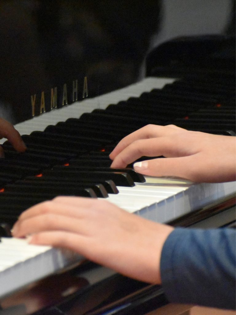 Les mains d'un adulte sur le clavier du piano à queue, pour le Studio 1170
